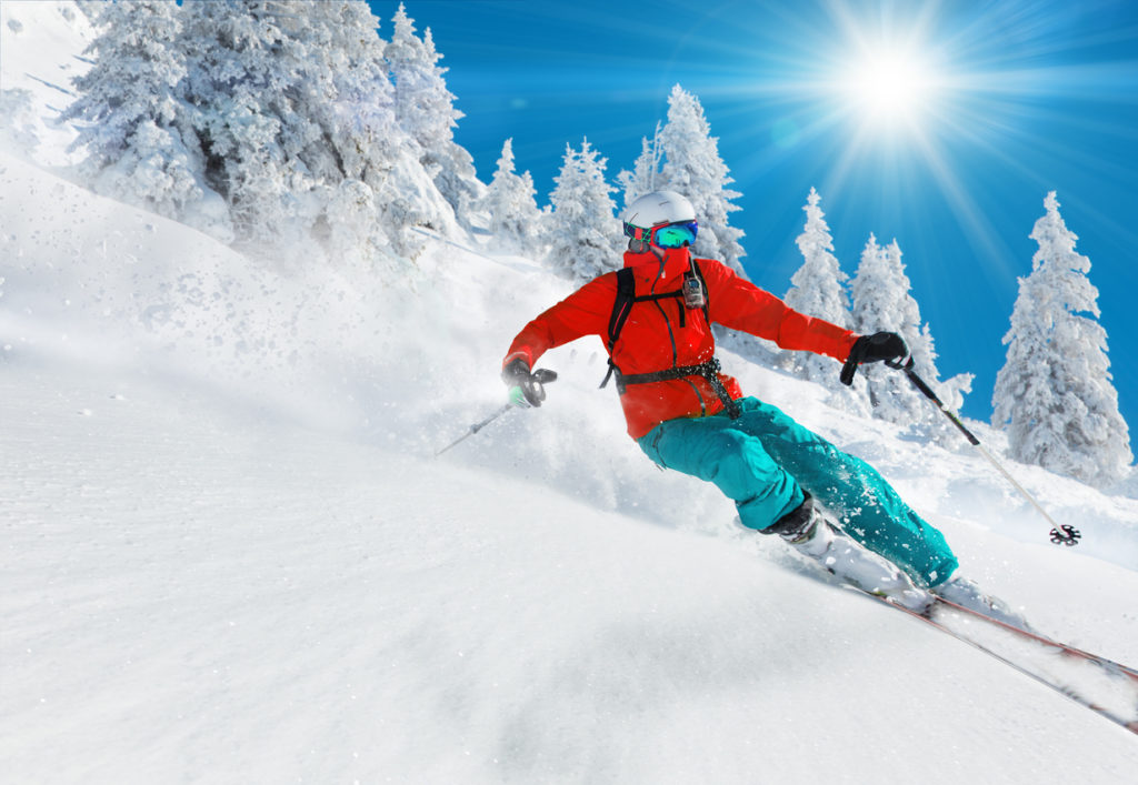 Skier skiing downhill in high mountains